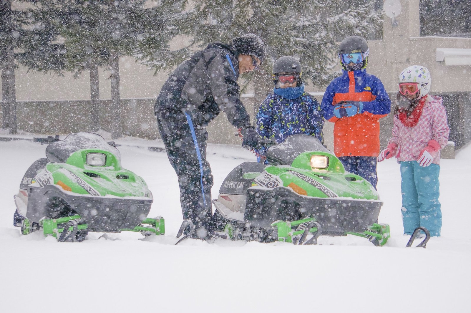 3 children learning how to drive a snowmobile safely