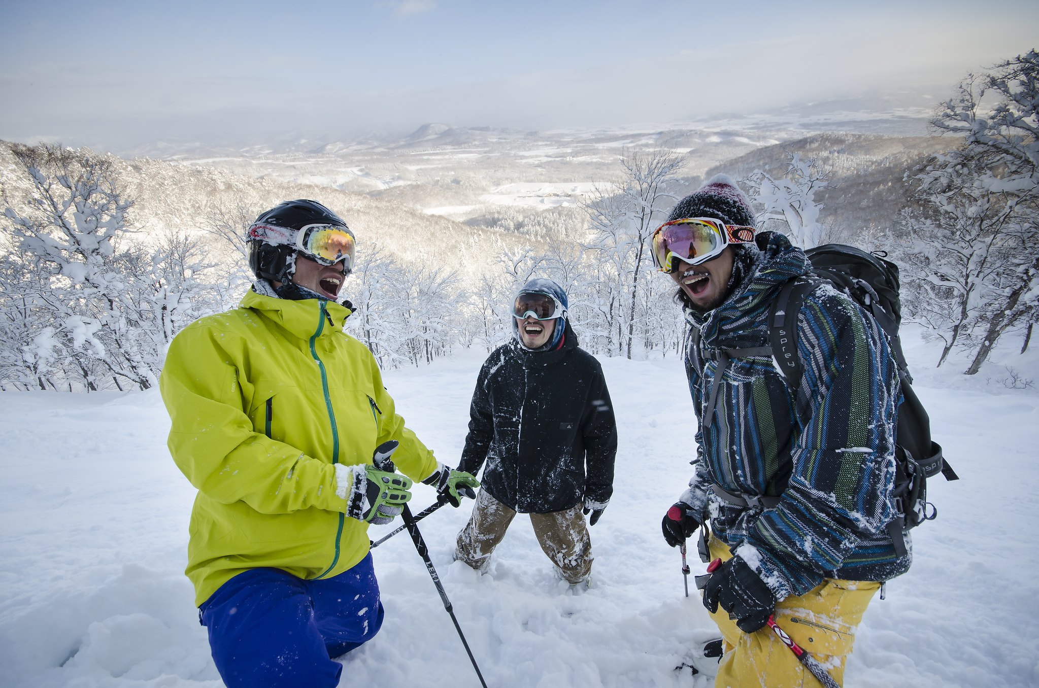 3 men laughing in the deep powder snow of Hanazono Resort, Niseko.